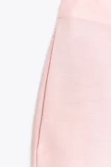 Bermuda de tiro medio color rosa, confeccionada en lino, con bolsillos delanteros y falsos bolsillos de vivo en la espalda.