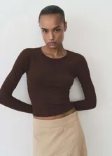 Remera marrón de punto ajustada al cuerpo, con cuello redondo y mangas largas.