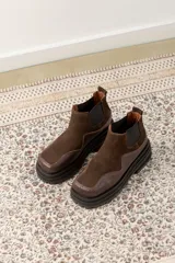 Botas Chelsea de cuero color marrón con paneles laterales elásticos negros y suela track de goma negra.