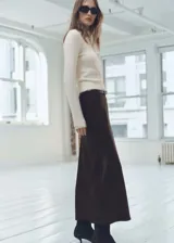 Sweater color beige de tejido de punto, con cuello solapa alto y mangas largas.