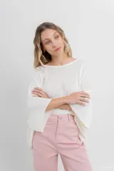 Sweater color crudo de tejido liviano con textura semi traslúcida, escote redondo y mangas amplias estilo murciélago.