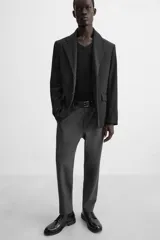 Pantalón slim fit negro confeccionado en tejido con elasticidad en ambas direcciones. Cuenta con bolsillos frontales y traseros de vivo con botón. Cierre frontal con cremallera y botón.