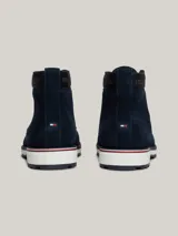 Botines Tommy Hilfiger de hombre, color azul marino, confeccionados en ante con interior de poliéster y suela de goma. Presentan cordones, logo Hilfiger en el tobillo y detalle distintivo en el talón.