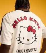 Remera blanca de corte boxy con cuello redondo y detalles en negro. Estampado frontal con logo de Hello Kitty y texto "Sport Club".