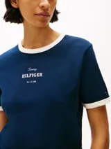 Remera azul marino de algodón con cuello redondo y mangas cortas con ribetes blancos. Logo de Tommy Hilfiger bordado en el pecho.