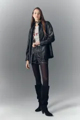 Camisa de cuero ovino negro con efecto arrugado, de moldería amplia, con cuello camisero y botones a presión con logo.