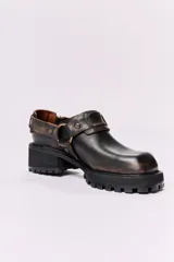 Zuecos de cuero con estampado animal print blanco y negro, con plataforma y hebillas metálicas.