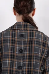 Blazer de corte relajado con estampa tartán, diseño cruzado y hombros caídos.