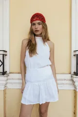 Top blanco de lino con cuello halter, elástico en los costados, espalda abierta y abotonado en el cuello.