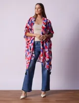 Kimono tejido con estampado floral multicolor y terminación de ruedo con borlas negras.
