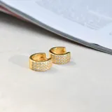 Aros tipo argolla pequeños, dorados, con tres hileras de circonias engarzadas.