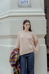 Sweater beige de tejido bouclé, con cuello redondo y mangas largas.