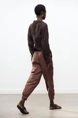 Pantalón jogger marrón de tiro alto con cintura elástica ajustable con cordones, bolsillos delanteros y puños elásticos en los tobillos.