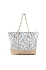 Bolso tipo tote playero con cuerpo estampado en patrón de hojas estilizadas en gris y blanco, y base de arpillera color beige. Las asas son de cuerda gruesa trenzada de color crudo.