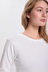 Remera blanca de algodón con textura acanalada, corte ajustado y mangas largas.