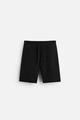 Bermuda negra de corte relaxed fit, con cintura elástica ajustable con cordón, bolsillos frontales y bolsillo trasero de parche.