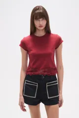 Remera cropped ajustada al cuerpo de algodón, color blanco, con cuello redondo y un borde inferior de encaje calado con diseño floral.