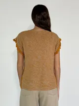 Top tejido color mostaza con escote en V y mangas cortas con detalle de crochet.