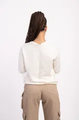 Buzo negro de algodón de corte clásico con cuello redondo y mangas largas. Tiene un pequeño logo bordado en el pecho.