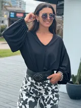 Blusón negro con escote en V y mangas globo.