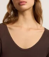 Blusa manga larga color marrón confeccionada en rib con detalle de encaje en el escote. Escote en U.