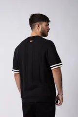 Camisa de tejido de punto color beige, con cuello tipo bowling, manga corta y corte relajado. Cierre frontal con botones.