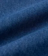 Camisa de jean azul oscuro, de corte clásico, con cuello tradicional, mangas largas con puños abotonados, bolsillo en el pecho y cierre frontal abotonado.