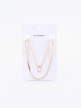 Collar dorado de doble cadena con dije rectangular blanco.