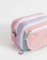 Cartuchera rectangular con divisiones internas, bolsillo frontal transparente con estampado de texto "Lucky Girl" y cierre superior con cremallera. Incluye tiracierres de silicona con logo de la marca.
