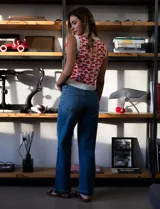 Chaleco tejido blanco con estampado floral rojo, escote en V y cierre frontal con botones.