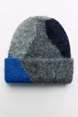 Gorro tipo beanie tejido con alpaca, con diseño de bloques de color en gris, azul y azul marino.
