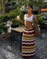 Pollera larga tejida a crochet con diseño de ondas horizontales en tonos borgoña, crema, amarillo, celeste y verde.