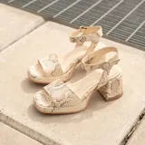 Sandalias de cuero color marrón con plataforma y tacón cuadrado. Tiras anchas sobre los dedos y tobillo con hebilla ajustable.