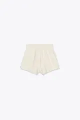 Shorts color crudo de tiro medio con cintura elástica ajustable con cordones y bajo desflecado.