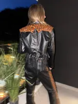 Campera corta de cuero negro, estilo torera, con animal print y flecos en la espalda.