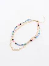 Collar doble dorado, uno con cadena de eslabones y otro con cuentas de colores.