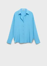Camisa celeste de tejido fluido con cuello camisero, cierre frontal con botones y mangas largas con puños abotonados.