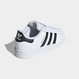 Zapatillas Adidas Superstar blancas con las tres tiras laterales en negro y puntera de goma.