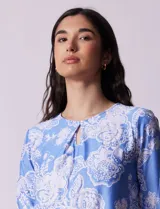 Blusa azul con estampado floral blanco, de seda fría, con cuello redondo con abertura y mangas 3/4 amplias con volados. Marca Ruby Rd.