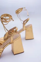 Sandalias rojas de cuero con plataforma y tiras para atar al tobillo.