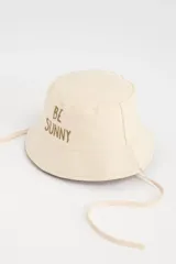 Gorro tipo bucket color beige con bordado frontal de la frase "Be Sunny" en marrón. Incluye cordones laterales ajustables.