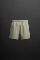 Shorts de entrenamiento color verde oliva confeccionados en tejido técnico ligero y elástico. Cuenta con cintura elástica ajustable con cordón interior, bolsillos frontales, bolsillo trasero de seguridad con cierre de cremallera, bajo con acabado termofijado, aberturas laterales y detalle de logo estampado en la pierna.