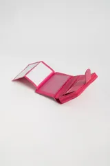 Billetera pequeña fucsia con textura símil cocodrilo, cierre con broche a presión y compartimento con cierre de cremallera.