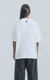 Remera blanca de algodón con corte crop, calce oversize, hombros caídos y cuello redondo.