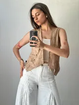 Pantalón blanco de corte palazzo con aplicaciones de encaje floral en los laterales.