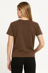 Remera blanca de algodón con estampado de flores azules y naranjas, de corte clásico y cuello redondo.