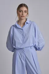 Camisa azul marino con bordados de flores blancas en mangas y falda.