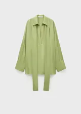Camisa oversize verde manzana de gasa con lazo en el cuello y aberturas laterales.
