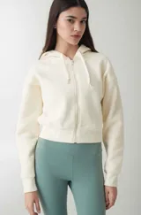 Campera deportiva color crudo, con cierre frontal y capucha, de ajuste cómodo.
