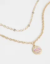 Collar corto dorado con doble cadena, una de eslabones grandes y otra de eslabones pequeños. Dije redondo con diseño de moño rosa y strass.